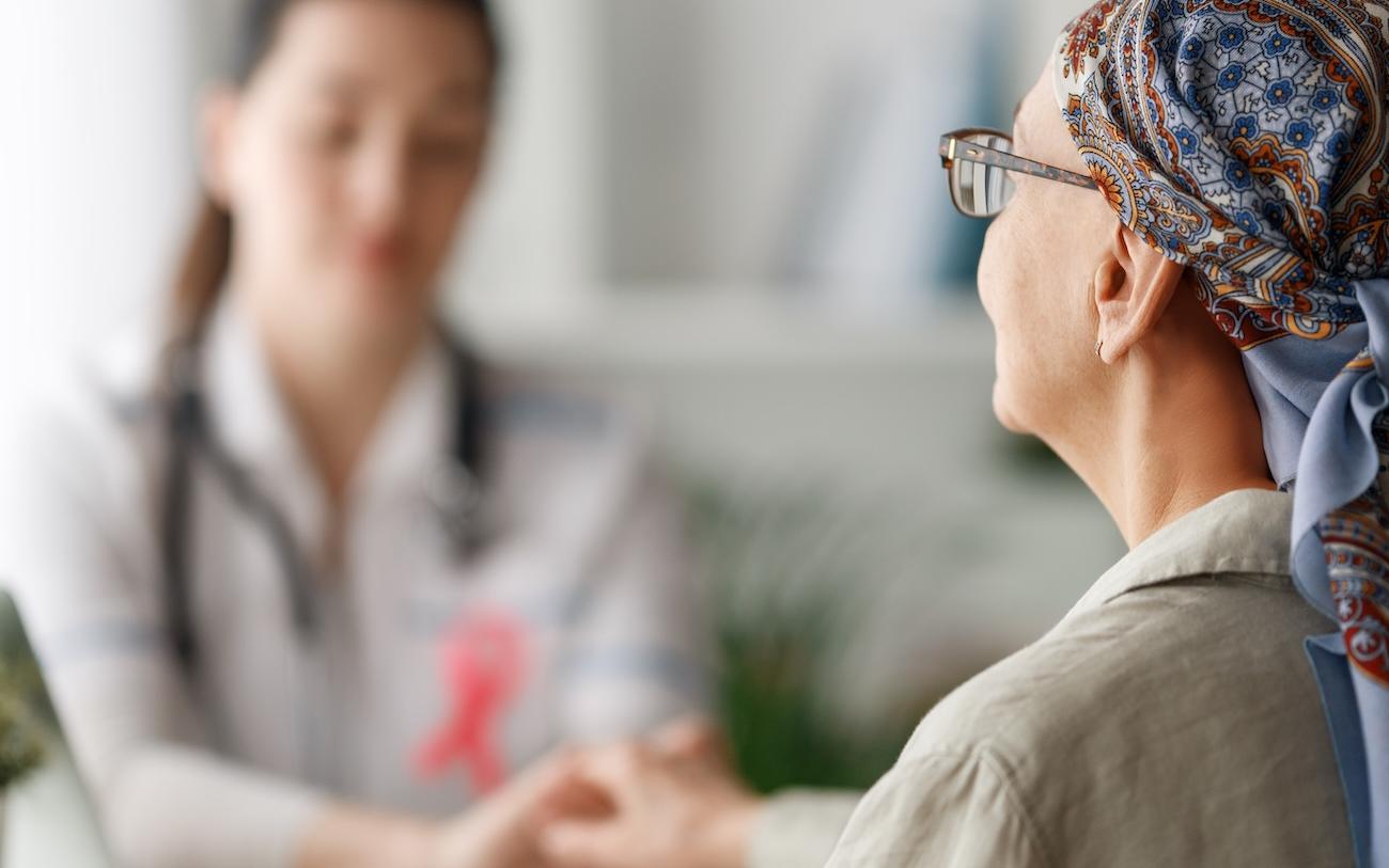 Ärztin hält die Hand einer Krebspatientin