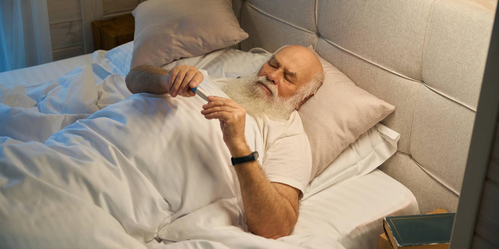Älterer Mann mit Pflegegrad 5 liegt im Bett
