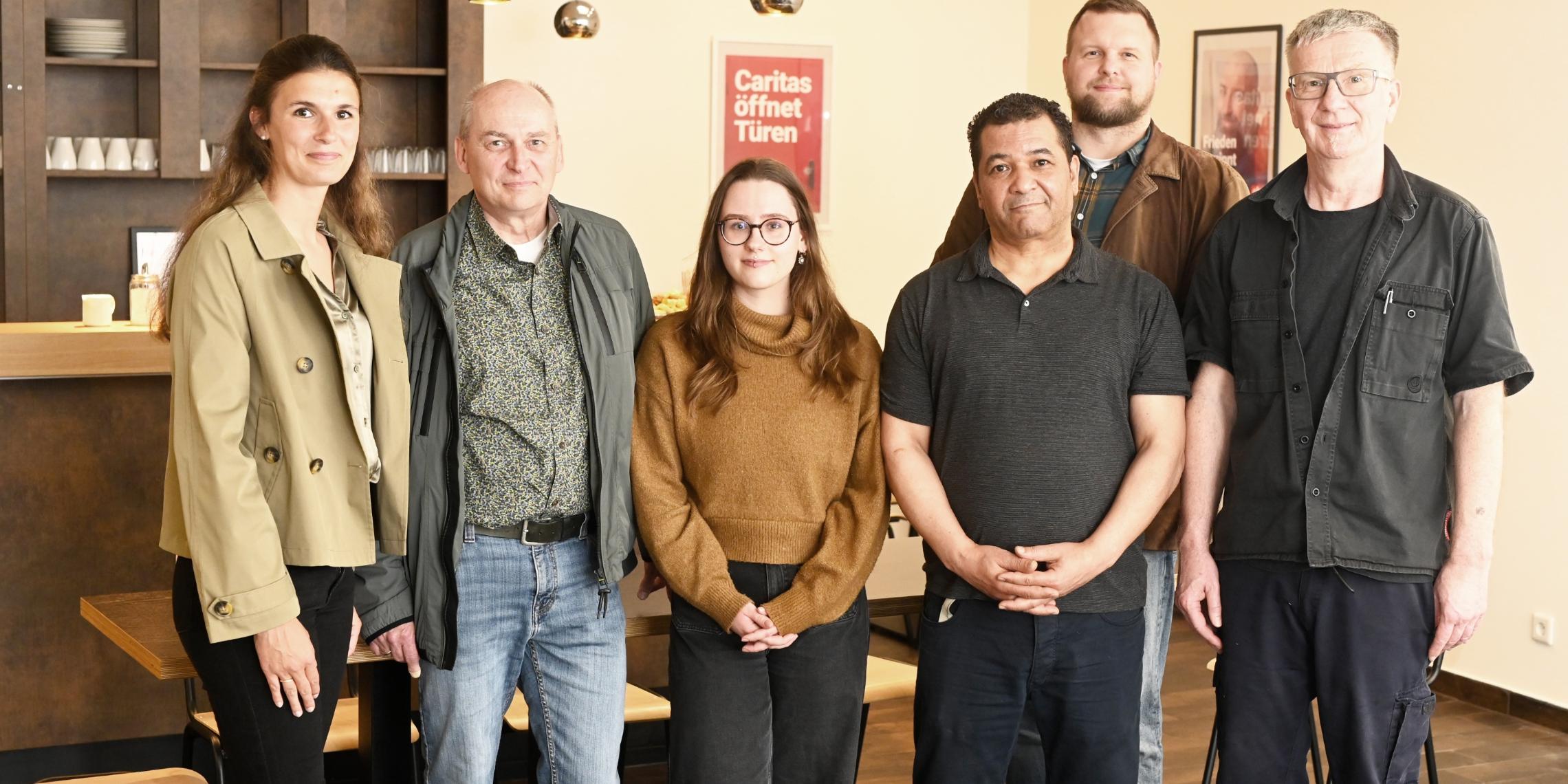 Das Caritas-Team Uli Ludemann, Fathi Touihri und Melissa Meyer (vorne von rechts) kümmert sich künftig um die Gäste im Tagesaufenthalt „StattRaum“. Zur Eröffnung gratulieren Vorstand Benjamin Lampa (zweite Reihe rechts), Klaus Heidemann (Fachbereichsleitung Wohnungslosen-/Gefährdetenhilfe Nordkreis, 2.v.l.) und Marie Peeters (Leitung CaritasSozialdienste, links). Zum „StattRaum“-Team gehört auch die Köchin Yvonne Schwendel, die beim Fototermin verhindert war.