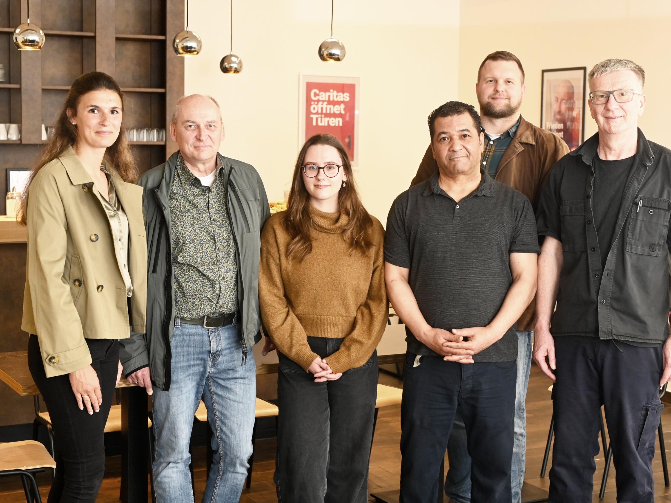 Das Caritas-Team Uli Ludemann, Fathi Touihri und Melissa Meyer (vorne von rechts) kümmert sich künftig um die Gäste im Tagesaufenthalt „StattRaum“. Zur Eröffnung gratulieren Vorstand Benjamin Lampa (zweite Reihe rechts), Klaus Heidemann (Fachbereichsleitung Wohnungslosen-/Gefährdetenhilfe Nordkreis, 2.v.l.) und Marie Peeters (Leitung CaritasSozialdienste, links). Zum „StattRaum“-Team gehört auch die Köchin Yvonne Schwendel, die beim Fototermin verhindert war.