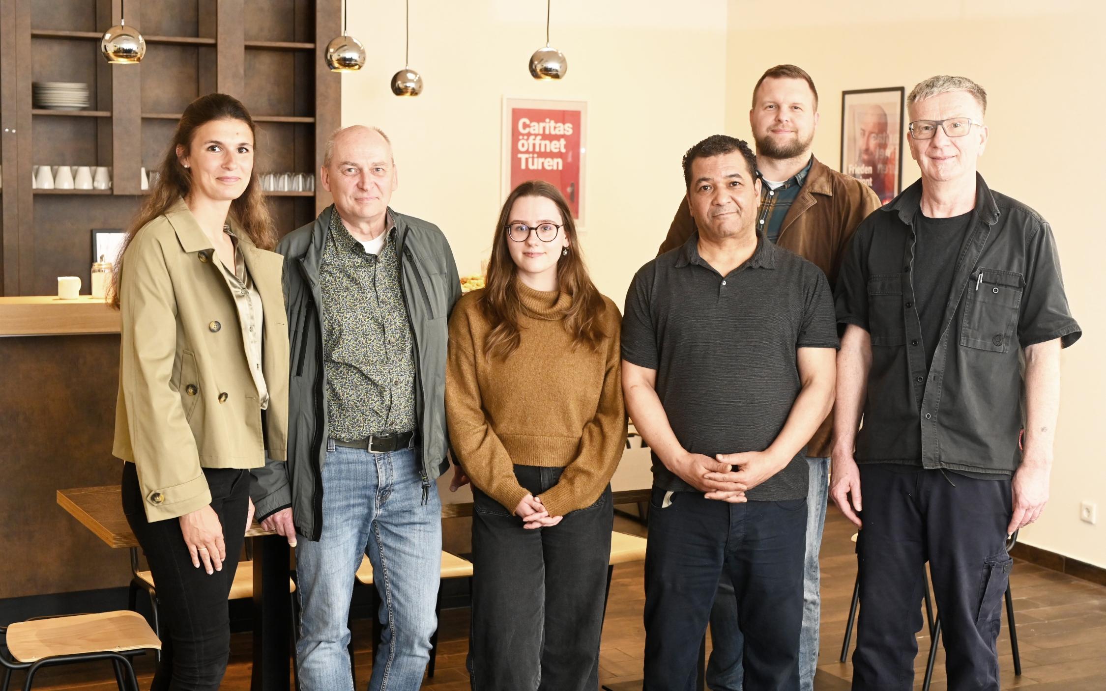 Das Caritas-Team Uli Ludemann, Fathi Touihri und Melissa Meyer (vorne von rechts) kümmert sich künftig um die Gäste im Tagesaufenthalt „StattRaum“. Zur Eröffnung gratulieren Vorstand Benjamin Lampa (zweite Reihe rechts), Klaus Heidemann (Fachbereichsleitung Wohnungslosen-/Gefährdetenhilfe Nordkreis, 2.v.l.) und Marie Peeters (Leitung CaritasSozialdienste, links). Zum „StattRaum“-Team gehört auch die Köchin Yvonne Schwendel, die beim Fototermin verhindert war.